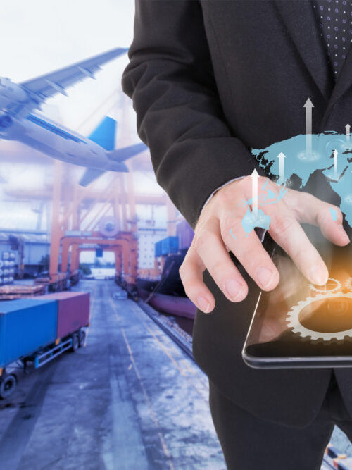 Image of businessman holding tablet ,Growing business concept on Global network coverage world map , Logistic Import Export background (Elements of this image furnished by NASA)